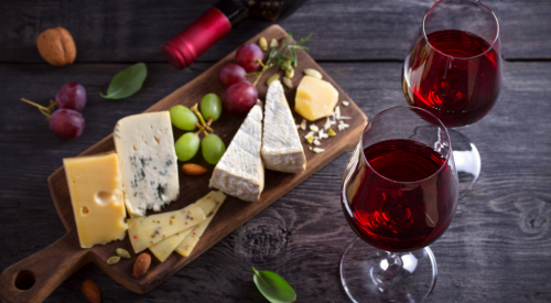 image of cheese board and two glasses of red wine